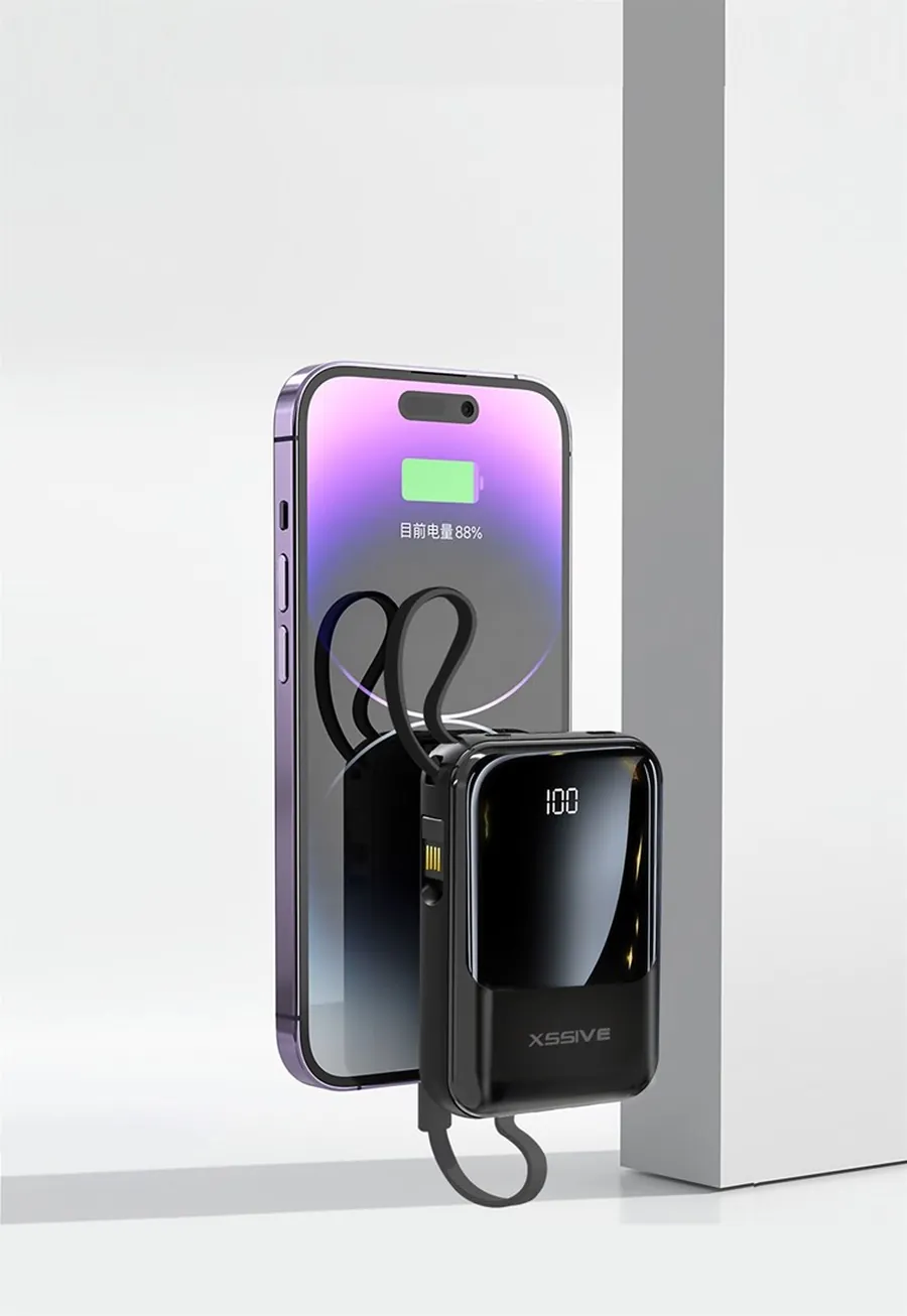 Compacte Xssive powerbank naast een telefoon